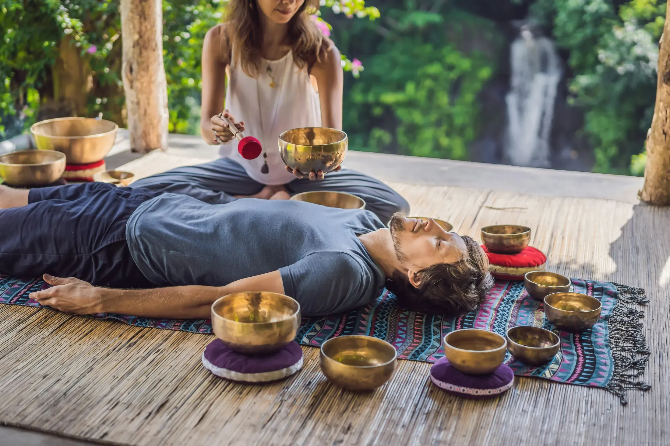 A couple drinking tea on a covered terrace during a tropical rain shower.