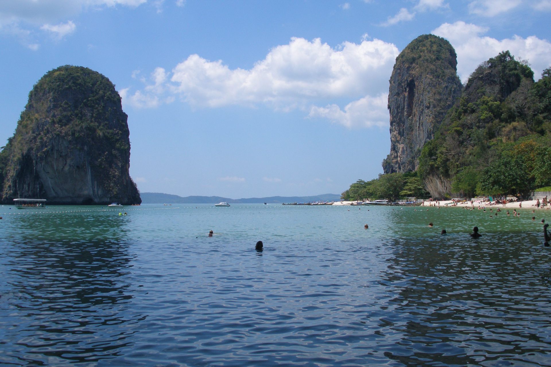 A travel planner reviews a Thailand itinerary beside a rain-streaked window.