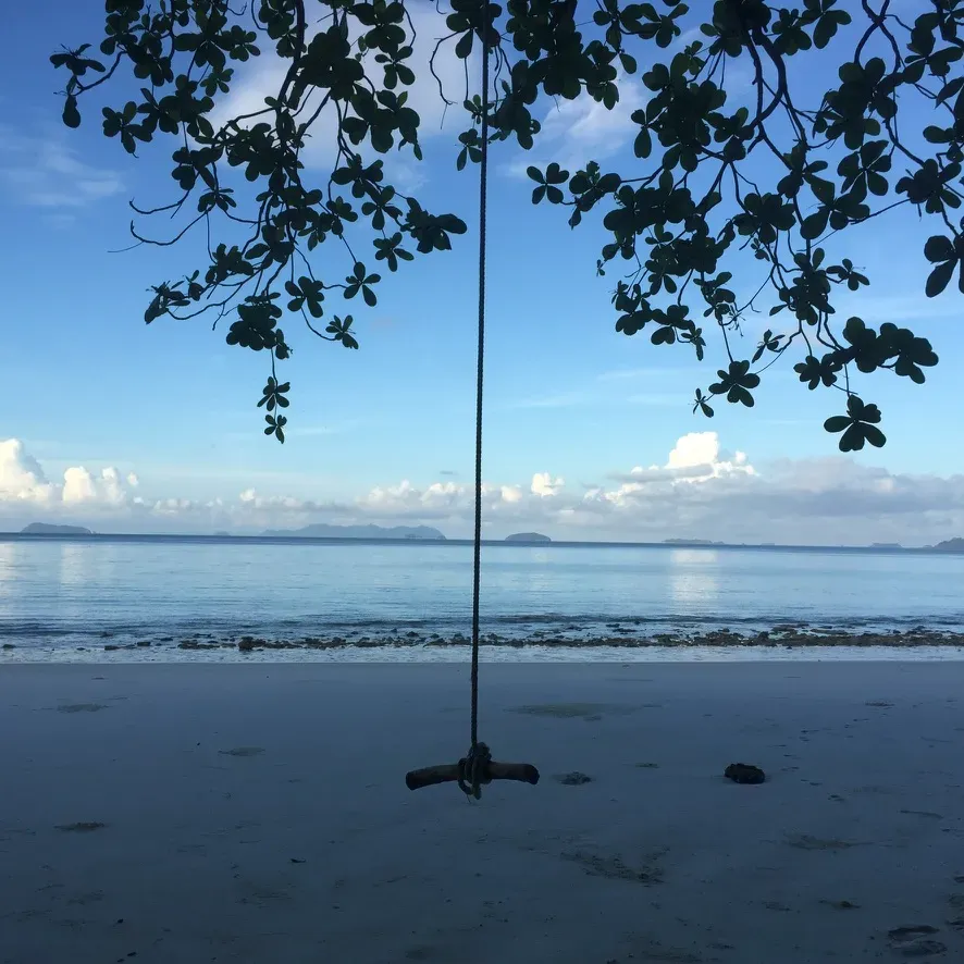 Solo traveler beside calm Thai water beneath a red band reading "Plan With Purpose."